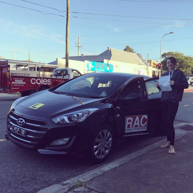 Person beside a dark RAC learner car